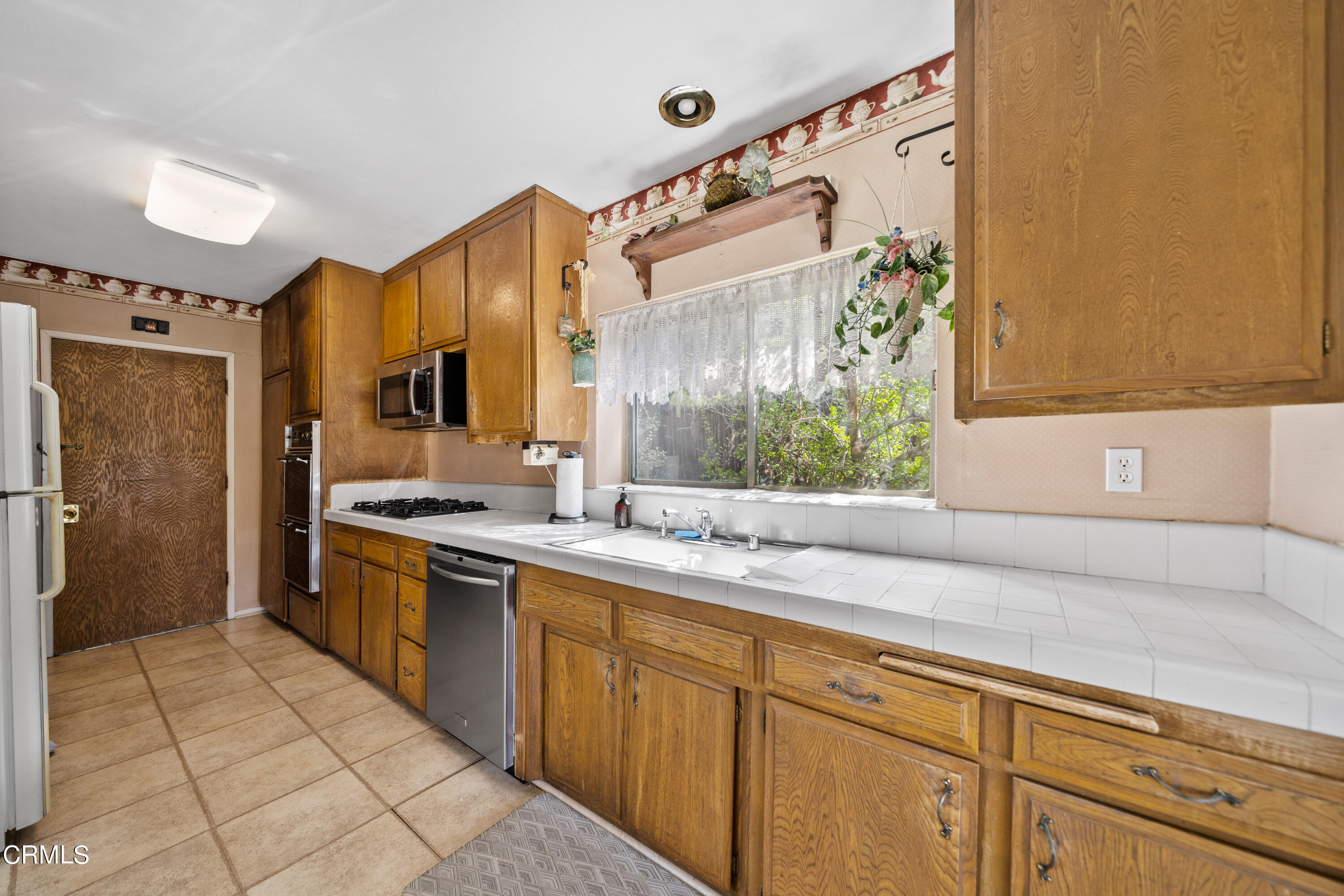 7024 Charrick Place Tujunga, CA 91042 - Photo 10 of 45 a kitchen with stainless steel appliances granite countertop a sink and a refrigerator