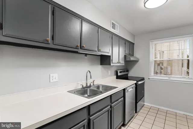 a kitchen with stainless steel appliances a sink a stove and cabinets