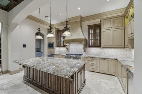 a kitchen with stainless steel appliances granite countertop wooden cabinets a sink and a refrigerator