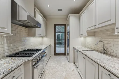 a kitchen with granite countertop a sink stove and cabinets