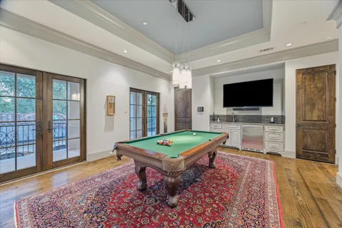 a living room with pool table flat screen tv and a rug