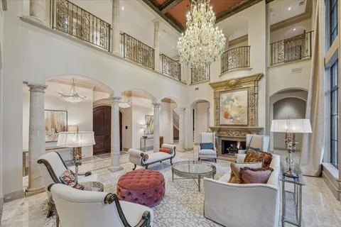 a living room with furniture a fireplace and a chandelier