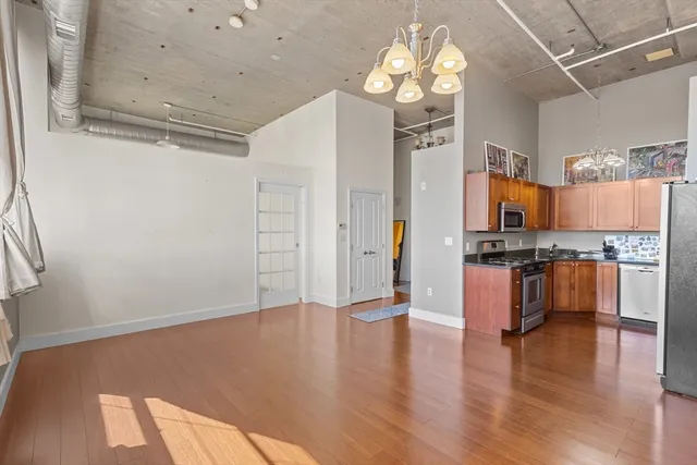 a view of kitchen with granite countertop cabinets and refrigerator