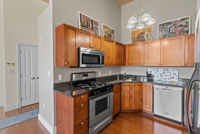 a kitchen with stainless steel appliances granite countertop a stove a sink and a microwave