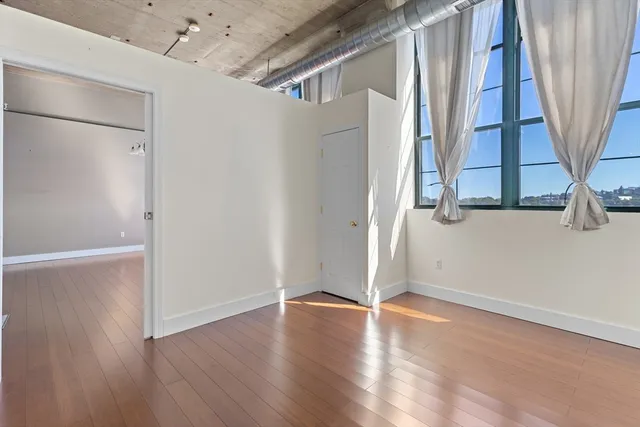 an empty room with wooden floor and entrance