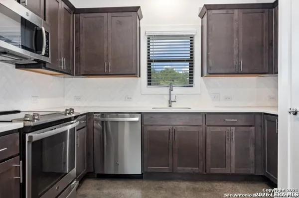 a kitchen with stainless steel appliances granite countertop a sink stove and microwave