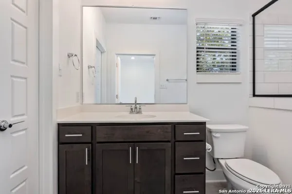 a bathroom with a sink a toilet and a mirror