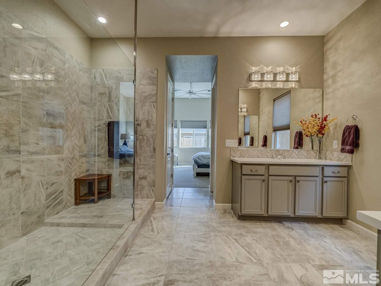 9440 Stony Hill Road Reno, NV 89521 - Photo 16 of 24 a bathroom with a double vanity sink a mirror and a shower