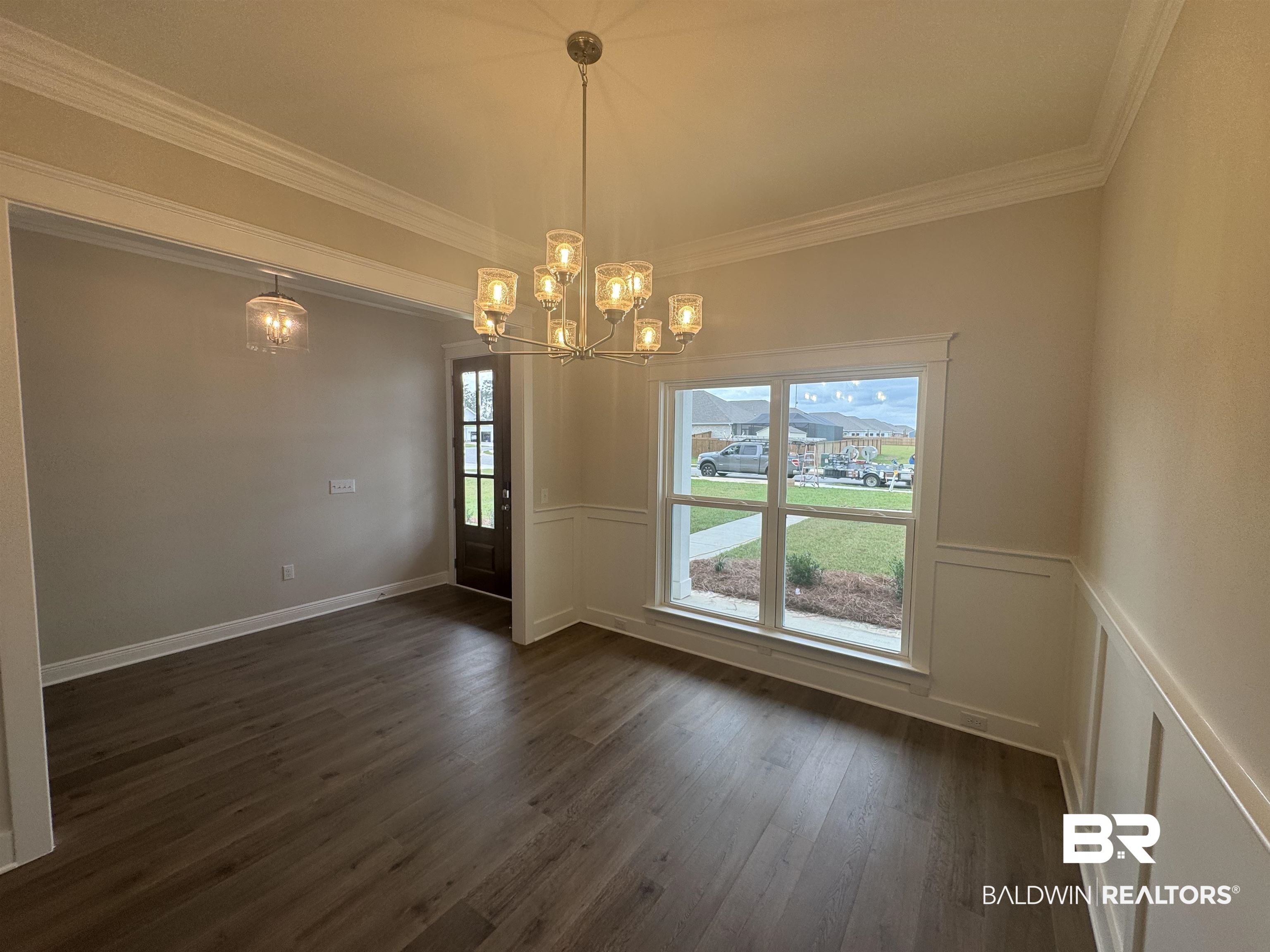 8090 Calverton Street, Unit 23 Foley, AL 36535 - Photo 6 of 30 Unfurnished room with dark wood-type flooring, a chandelier, and ornamental molding