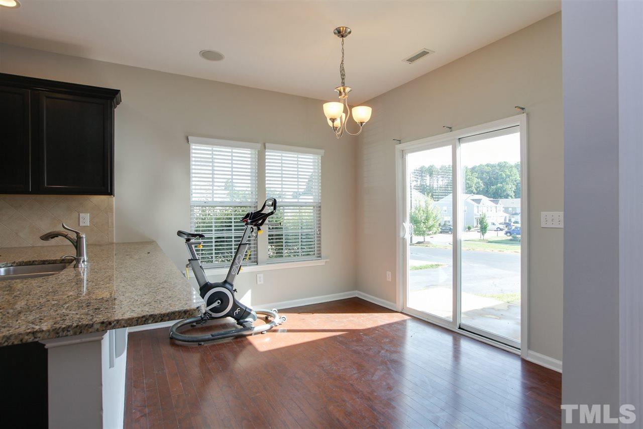 1025 Ileagnes Road Raleigh, NC 27603 - Photo 11 of 25 a view of a kitchen with granite countertop wooden floor a counter top space and a ceiling fan