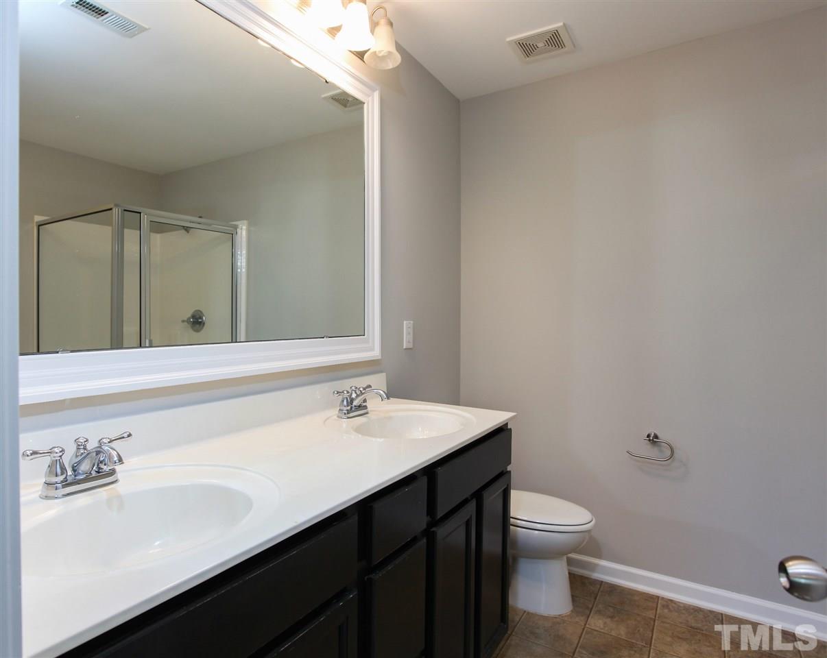 1025 Ileagnes Road Raleigh, NC 27603 - Photo 19 of 25 a bathroom with a sink a toilet and mirror