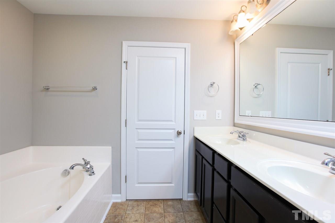 1025 Ileagnes Road Raleigh, NC 27603 - Photo 21 of 25 a bathroom with a tub a sink and a mirror