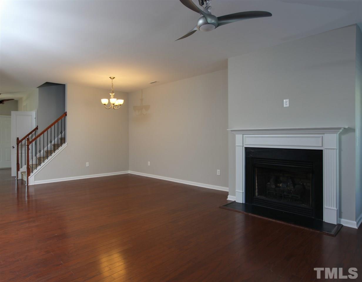 1025 Ileagnes Road Raleigh, NC 27603 - Photo 6 of 25 a view of an empty room with wooden floor fireplace and a window