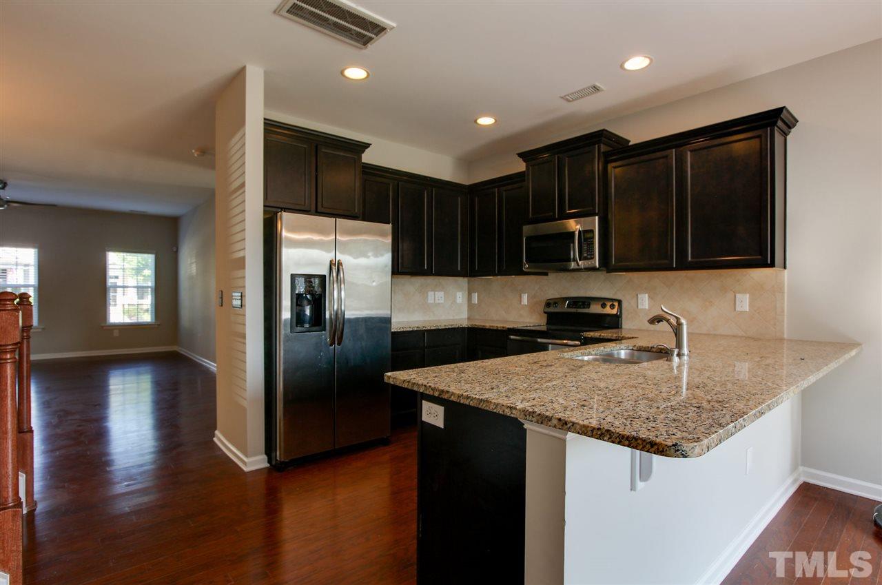 1025 Ileagnes Road Raleigh, NC 27603 - Photo 9 of 25 a kitchen with stainless steel appliances granite countertop a refrigerator a sink a stove a microwave and wooden cabinets