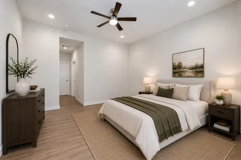 a bedroom with a large bed and a chandelier