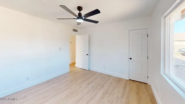 a view of a big room with wooden floor closet and windows