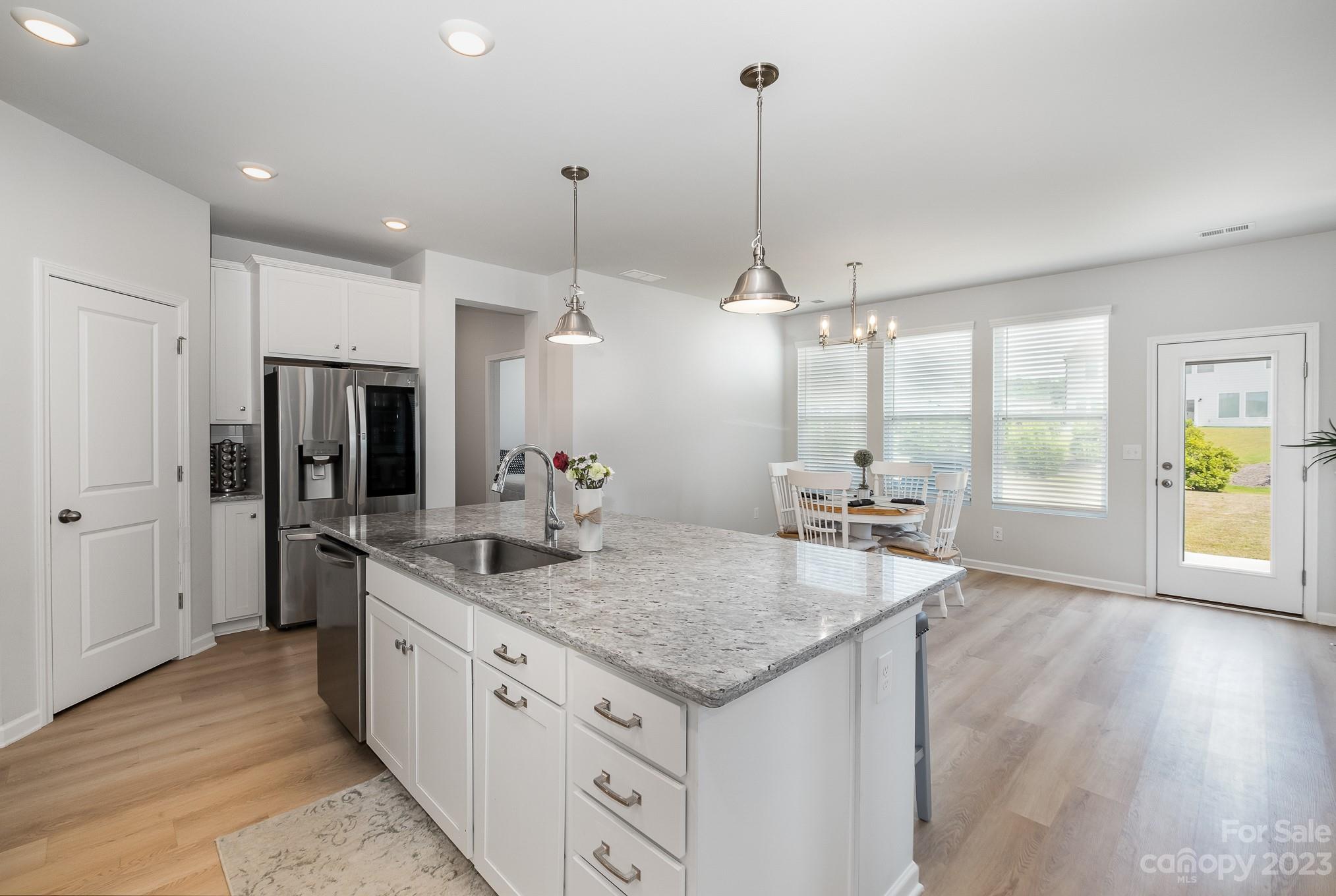 7015 Messina Road Indian Land, SC 29707 - Photo 9 of 42 a kitchen with stainless steel appliances granite countertop a sink a refrigerator a stove and a wooden floors