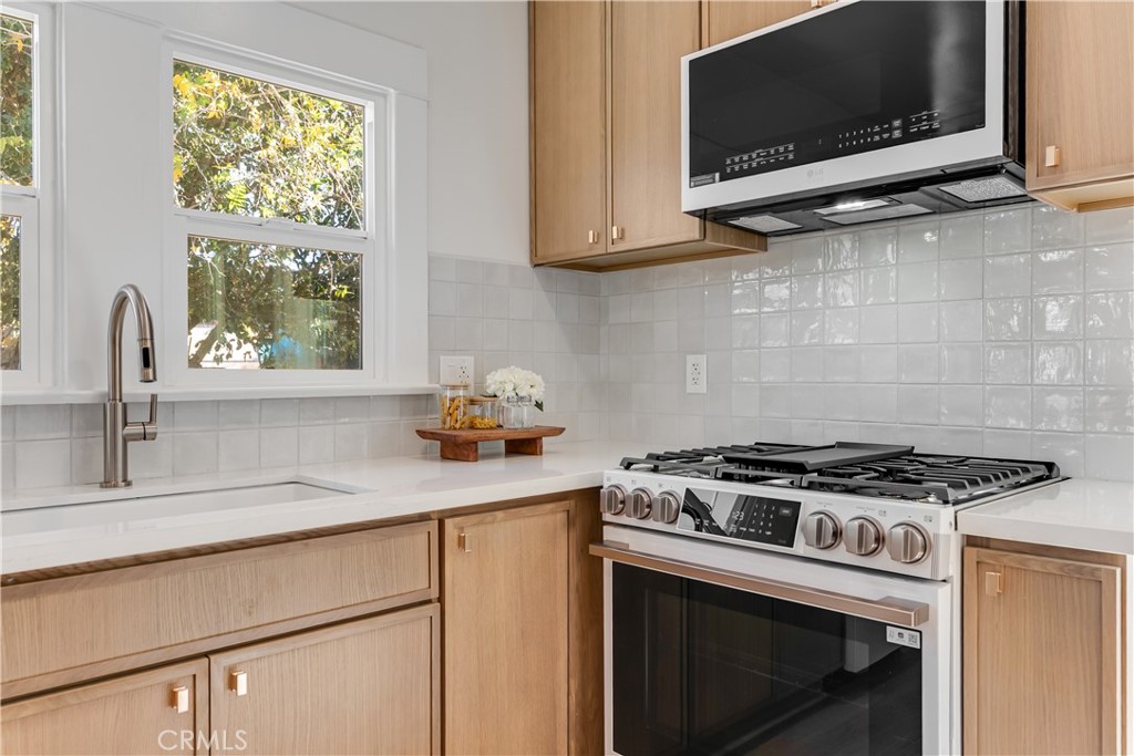 400 Flower Street Pasadena, CA 91104 - Photo 14 of 37 a kitchen with stainless steel appliances a stove a microwave a sink and cabinets
