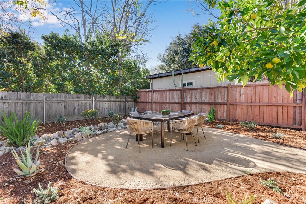 400 Flower Street Pasadena, CA 91104 - Photo 33 of 37 a view of a backyard with table and chairs potted plants and wooden fence