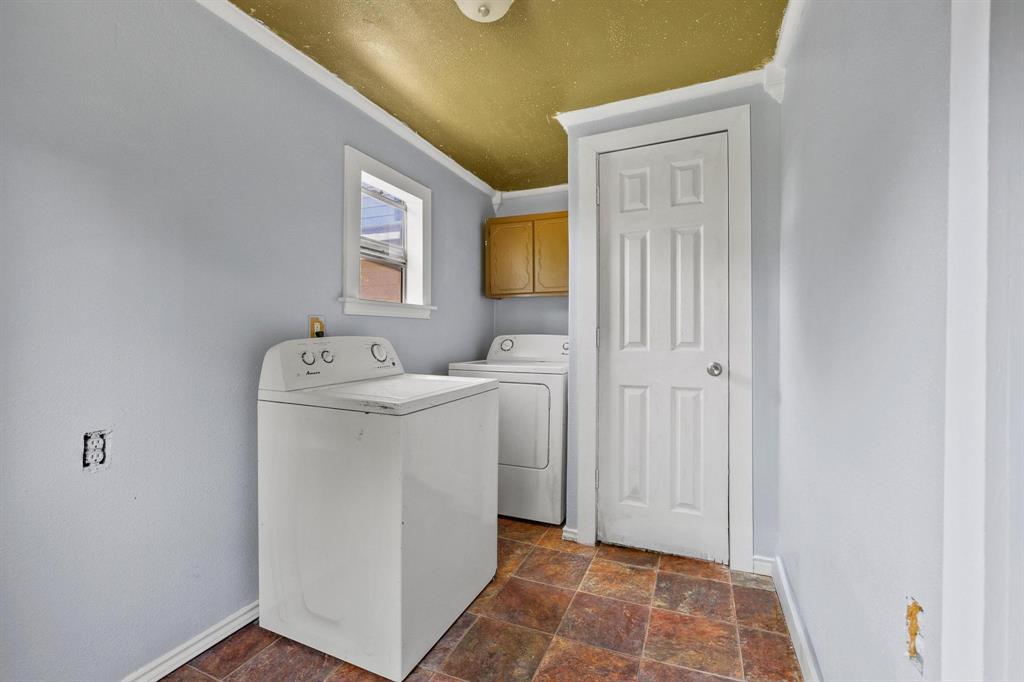 4453 Farm To Market 902 Howe, TX 75459 - Photo 32 of 40 Utility space featuring a window, brown tile-look flooring, light blue walls, and a built-in wood-tone cabinet