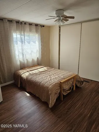 a bedroom with a bed and wooden floor