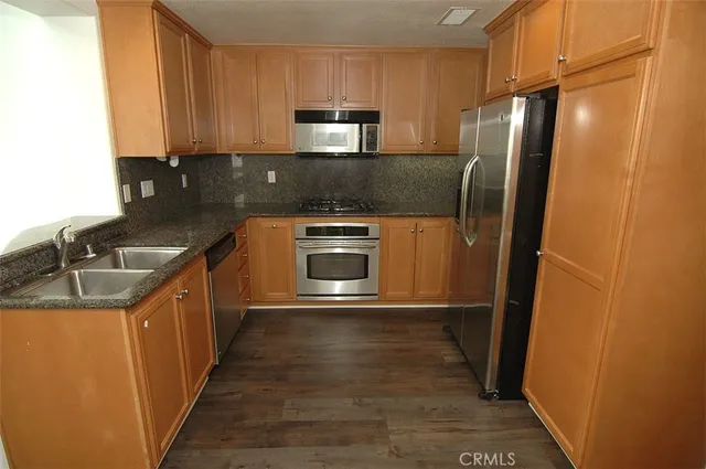 a kitchen with granite countertop a refrigerator and a sink