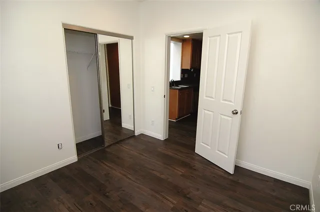 an empty room with wooden floor and closet