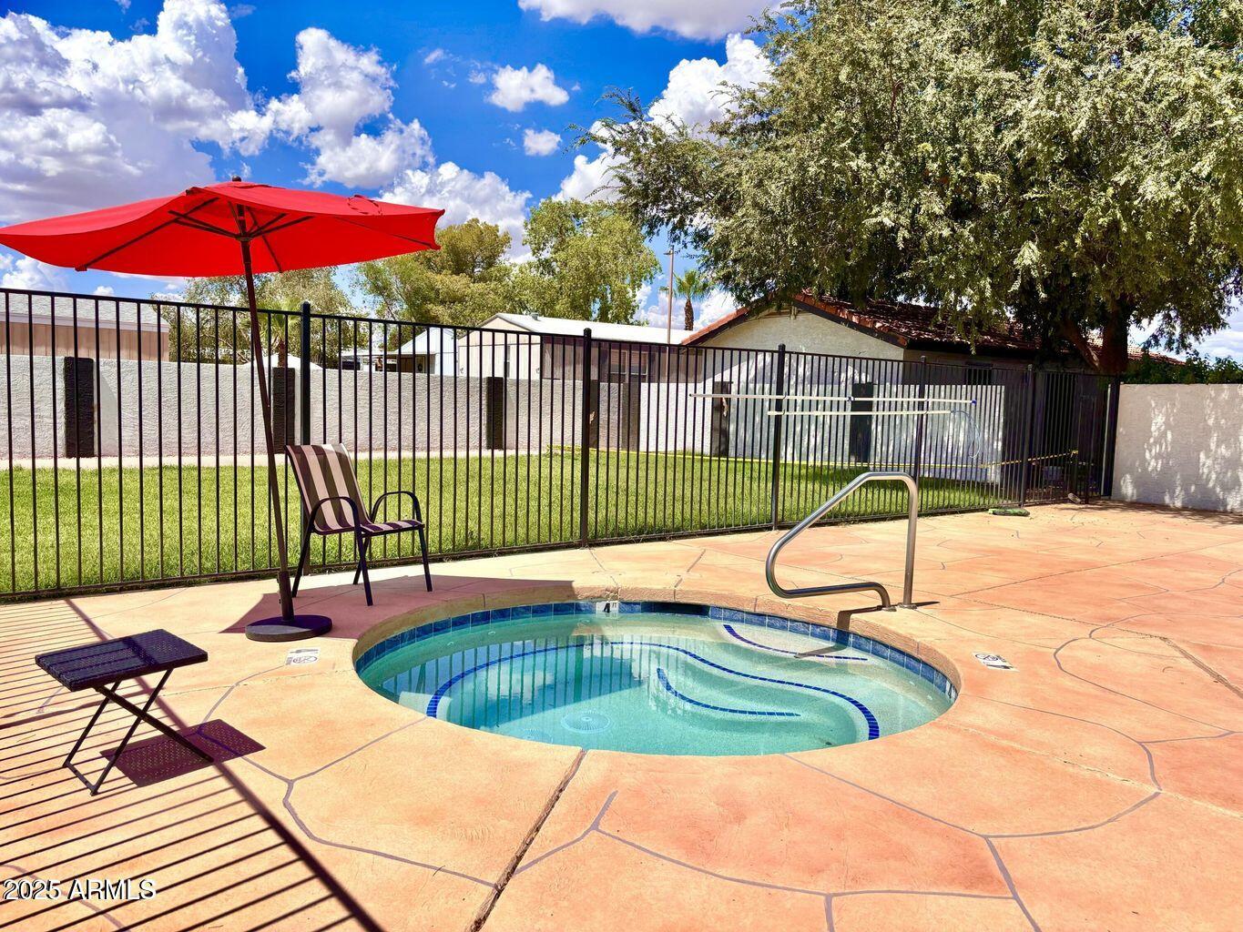 12721 West Greenway Road, Unit 114 El Mirage, AZ 85335 - Photo 5 of 10 a view of a swimming pool with a patio and a garden