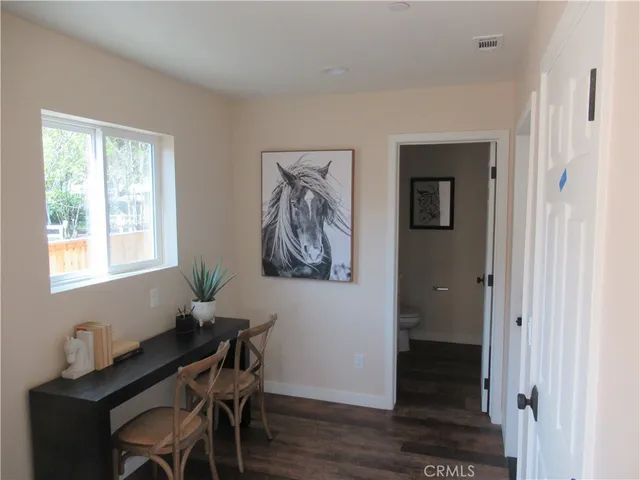 a view of a workspace with furniture and a window