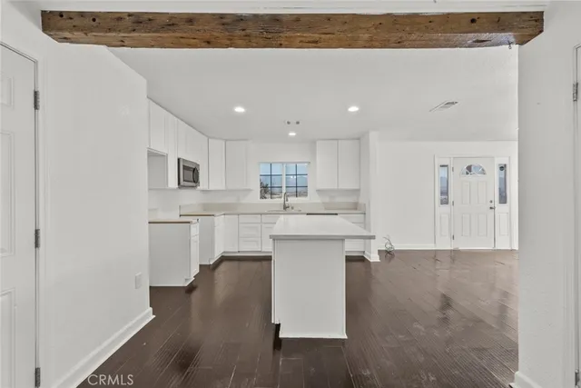 a kitchen with white cabinets and sink