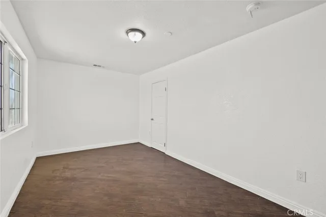 a bathroom with a granite countertop double vanity sink a toilet and a mirror
