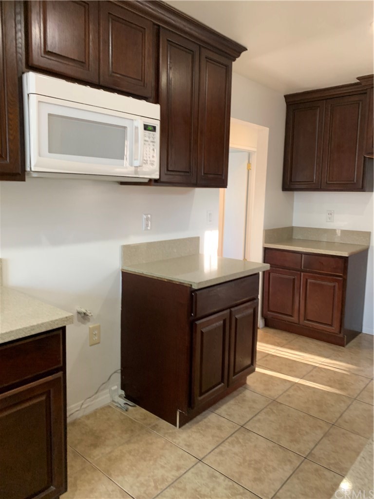 8216 Wilbarn Street Paramount, CA 90723 - Photo 12 of 27 a kitchen with stainless steel appliances granite countertop a stove microwave and cabinets