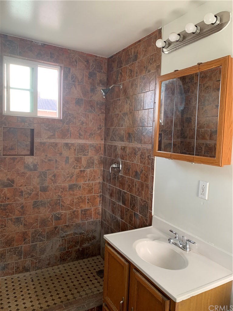 8216 Wilbarn Street Paramount, CA 90723 - Photo 20 of 27 a bathroom with a sink a mirror and shower