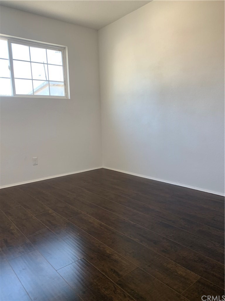 8216 Wilbarn Street Paramount, CA 90723 - Photo 22 of 27 an empty room with wooden floor and windows