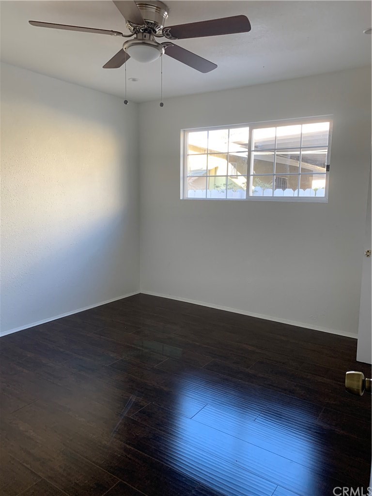 8216 Wilbarn Street Paramount, CA 90723 - Photo 5 of 27 an empty room with wooden floor and windows