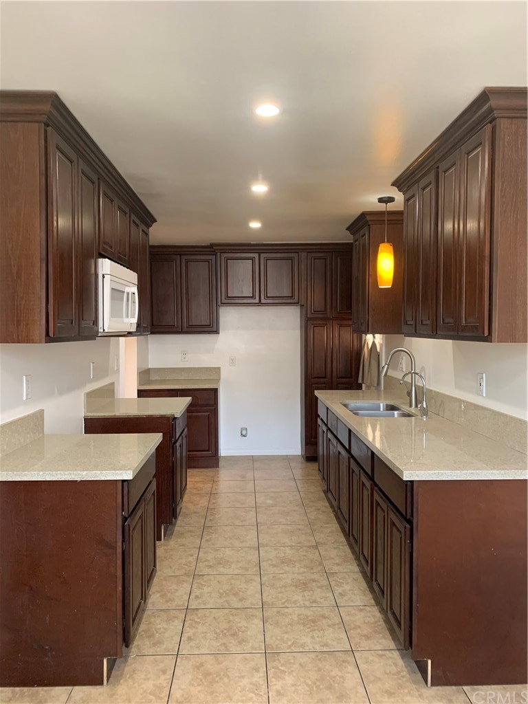 8216 Wilbarn Street Paramount, CA 90723 - Photo 10 of 27 a kitchen with a sink counter top space cabinets and stainless steel appliances