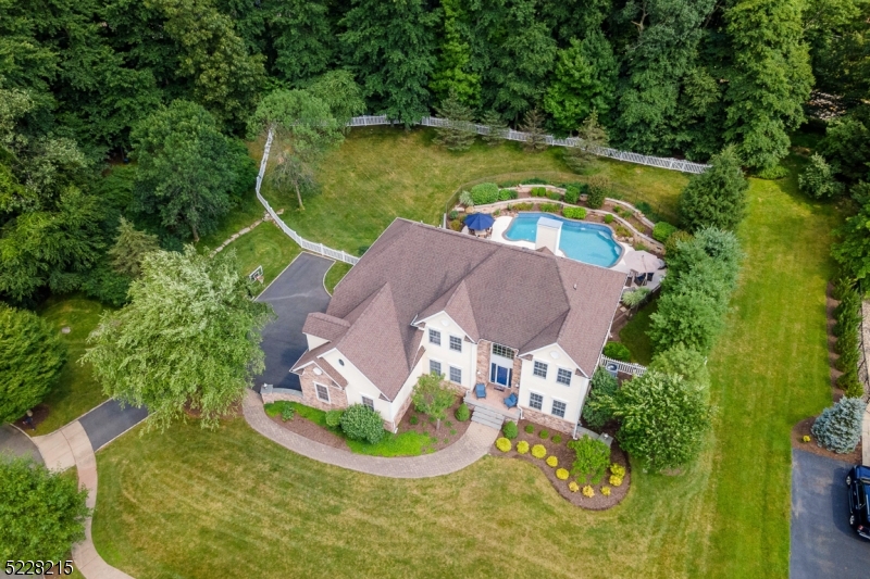 an aerial view of a house with a swimming pool and garden