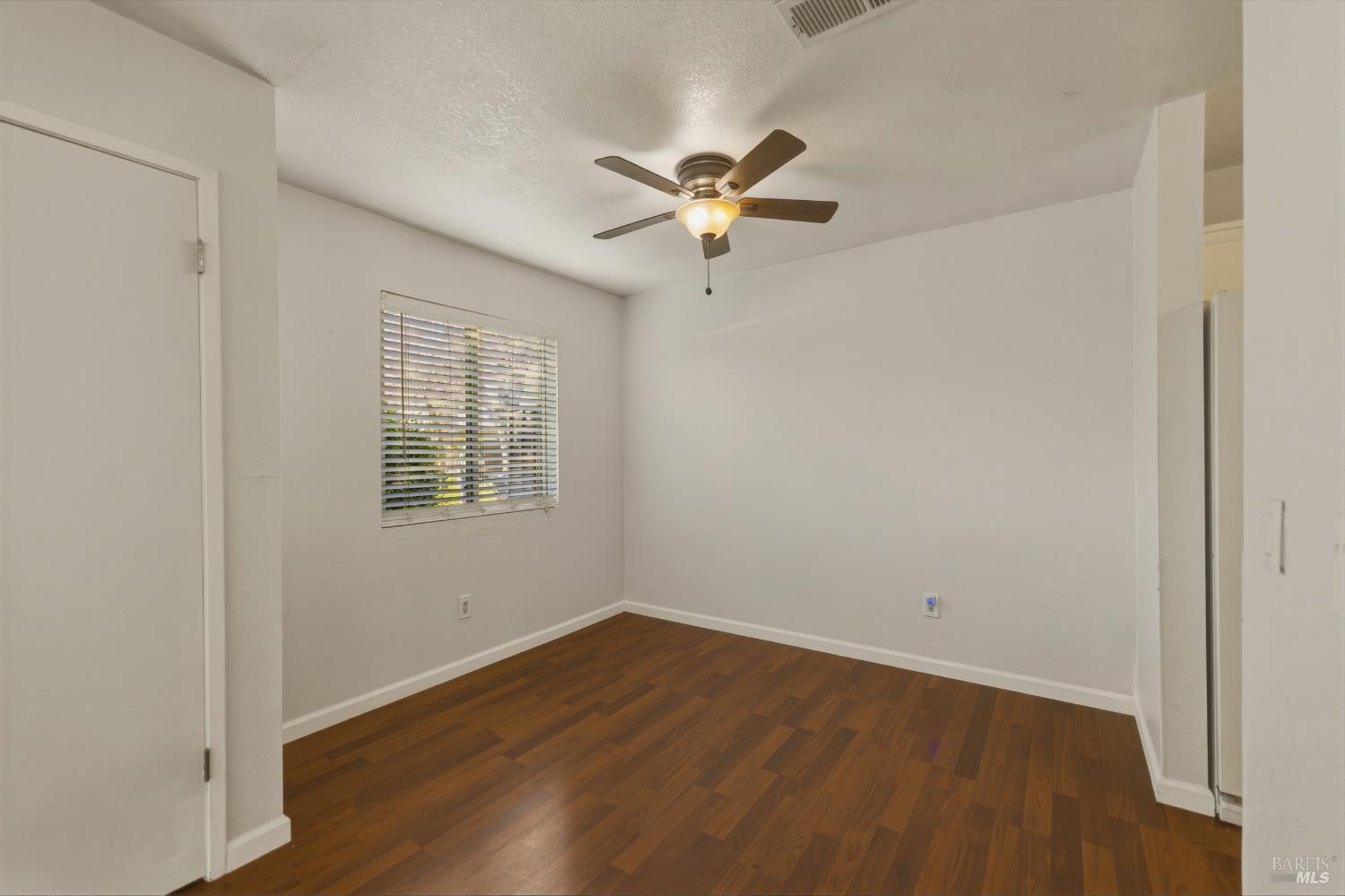1741 Las Raposas Court Santa Rosa, CA 95409 - Photo 13 of 27 an empty room with wooden floor fan and windows