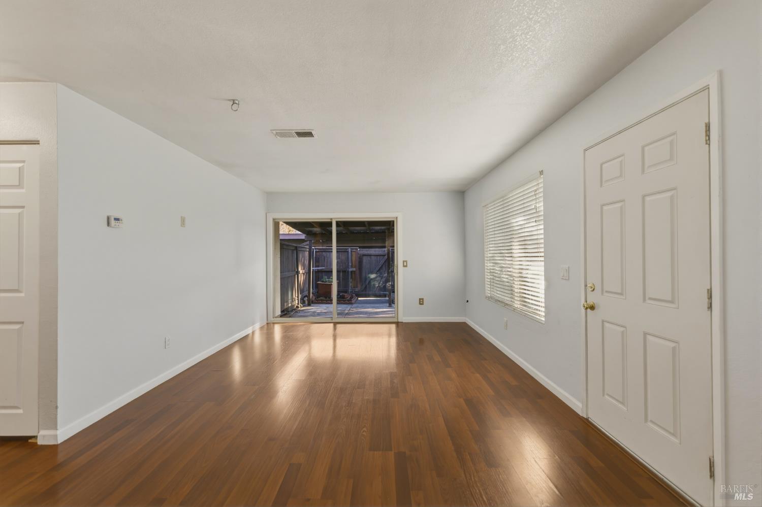 1741 Las Raposas Court Santa Rosa, CA 95409 - Photo 9 of 27 an empty room with wooden floor and windows