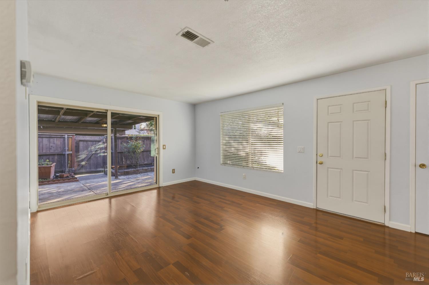 1741 Las Raposas Court Santa Rosa, CA 95409 - Photo 10 of 27 an empty room with wooden floor and windows