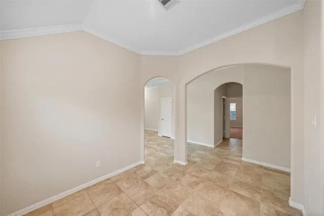 a view of an empty room with window and chandelier fan