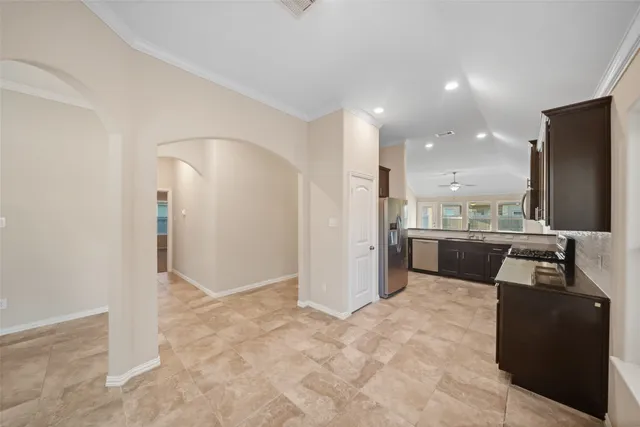 a view of an empty room with chandelier fan