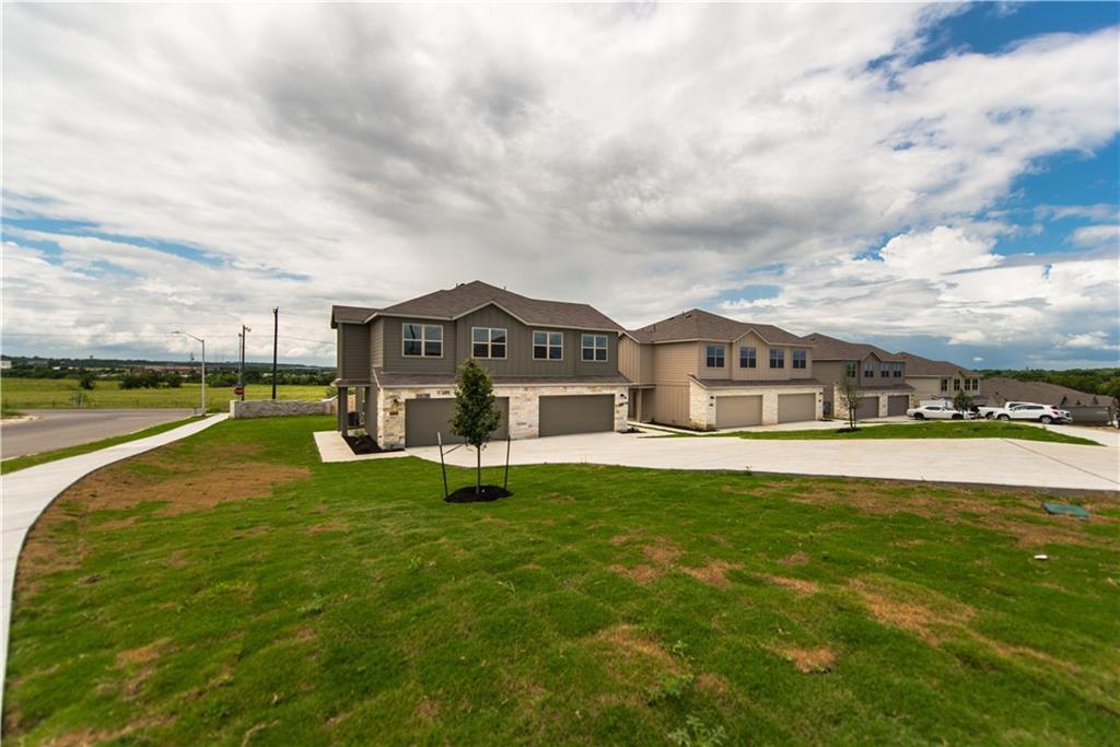 Contemporary multi-story residence featuring a two-car garage, stone and siding exterior finishes, and multiple windows