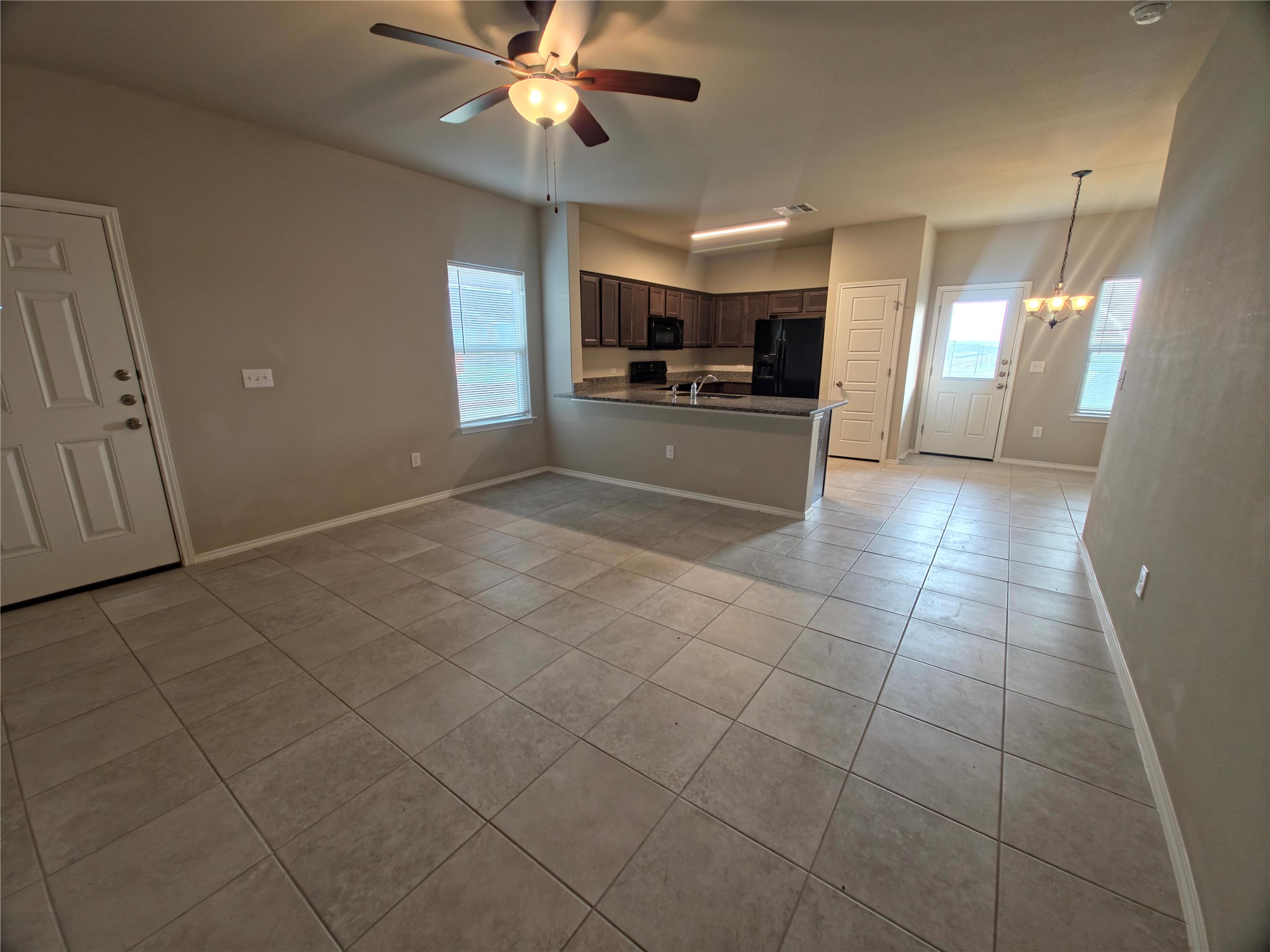 140 Dodge Road Georgetown, TX 78626 - Photo 2 of 14 Open-concept living area featuring neutral-toned tile flooring, a ceiling fan with integrated lighting, and multiple windows