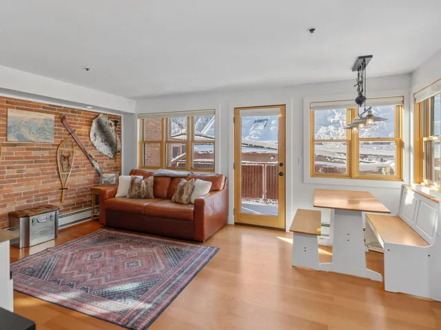 a living room with furniture a rug and white walls