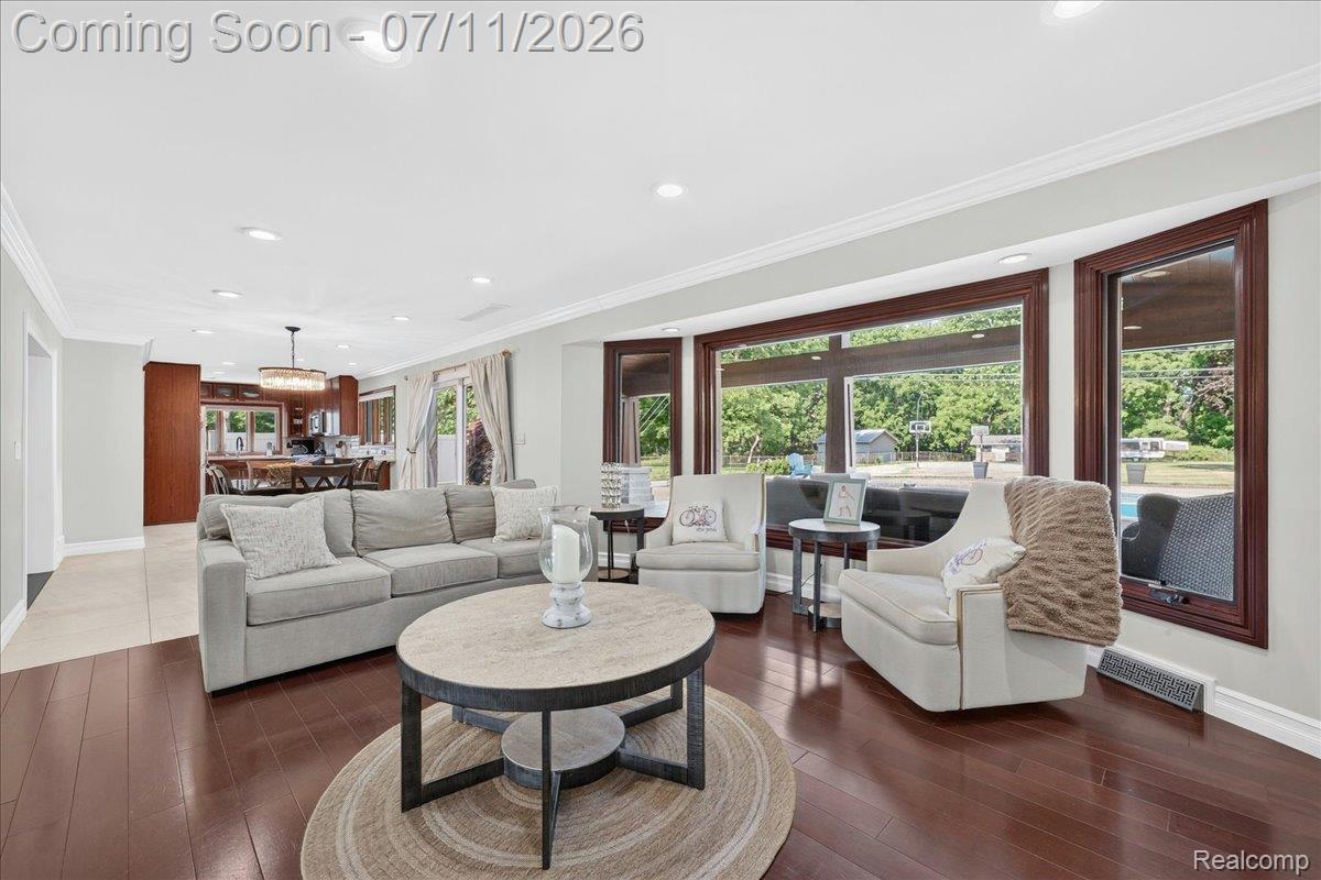 23750 East River Road Grosse Ile, MI 48138 - Photo 9 of 54 Spacious living area featuring rich wood-finish flooring and ample natural light from extensive bay windows