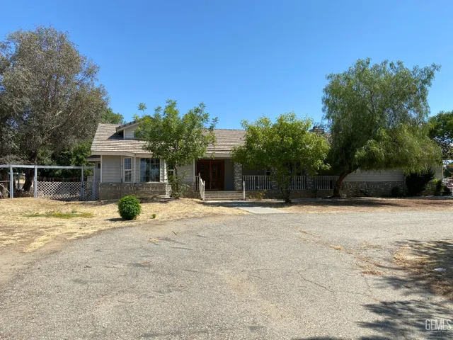 a view of a house with backyard and trees