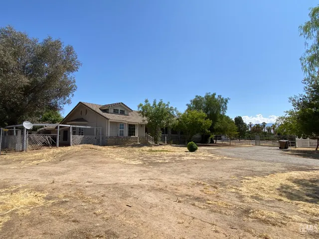a big house with large trees in front of it
