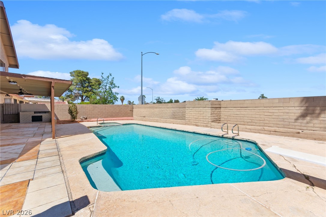 4430 Cranbrook Way Las Vegas, NV 89103 - Photo 5 of 50 An inviting backyard oasis awaits with a sparkling pool and a covered patio perfect for outdoor living.