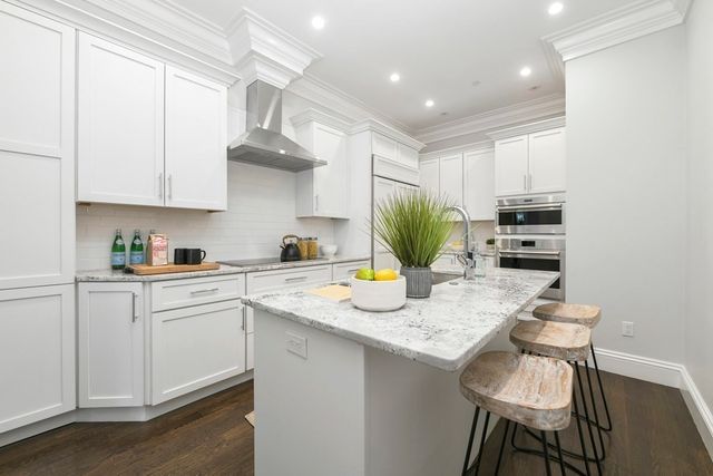 a kitchen with a sink a stove and chairs